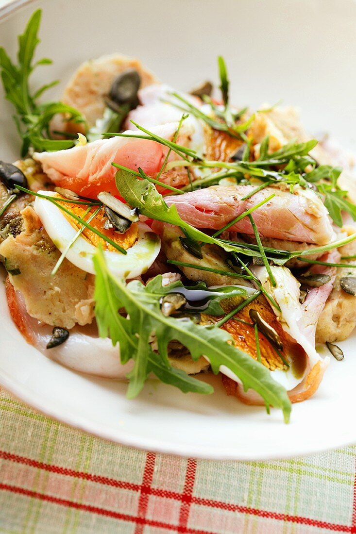 Salad with bread dumplings, ham, egg and rocket