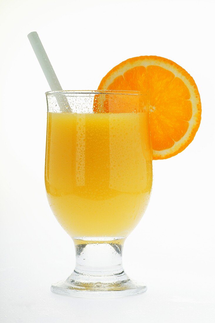 Orange juice in glass with straw and slice of orange
