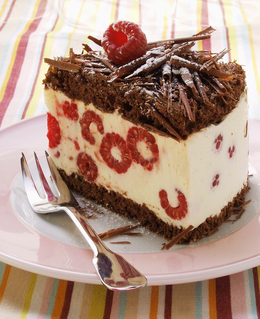 A piece of chocolate raspberry gateau with chocolate curls