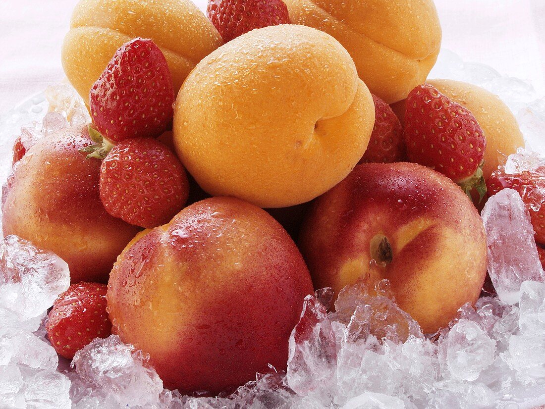 Aprikosen, Nektarinen und Erdbeeren auf zerstossenem Eis