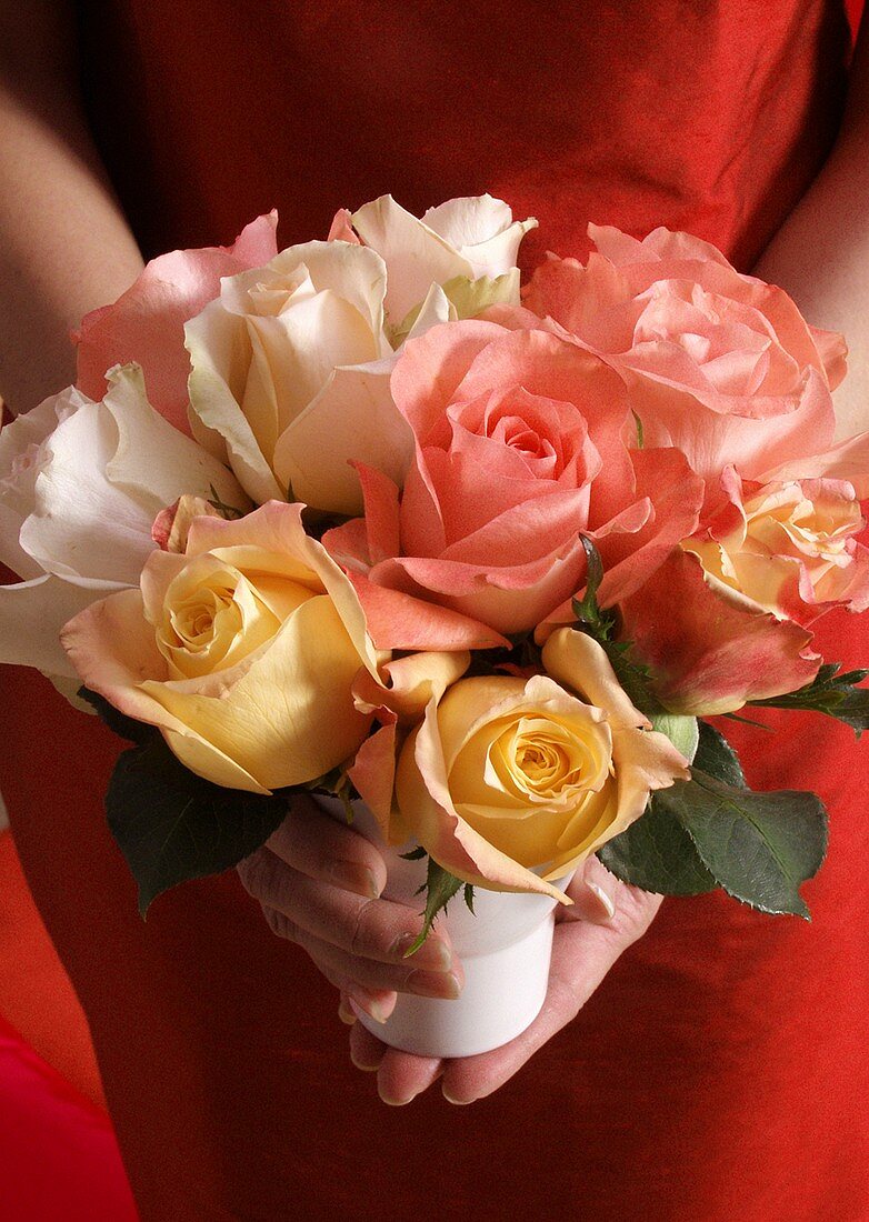 Woman in red dress holding bouquet of roses