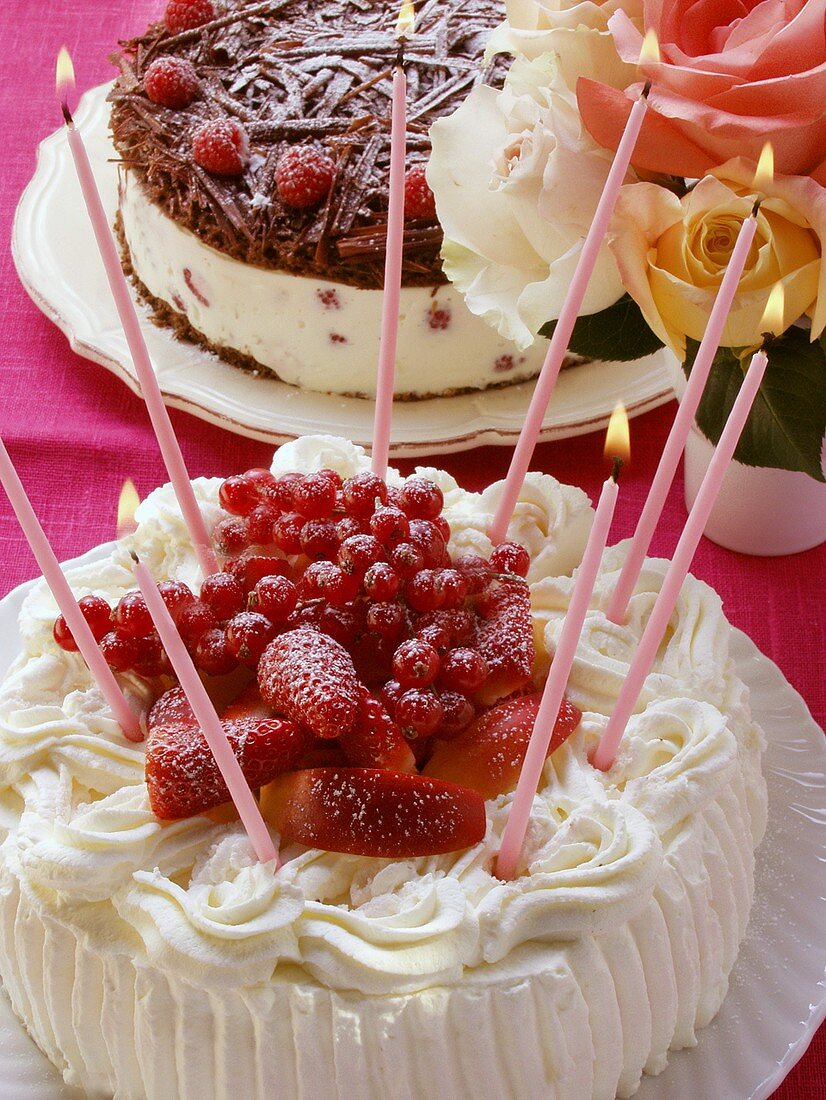 Sahnetorte mit Beeren und Kerzen; Schoko-Himbeer-Torte