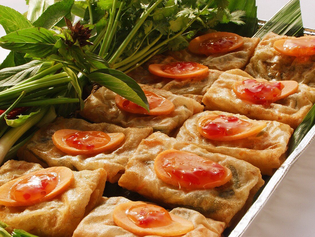 Spring rolls with carrots and herbs in aluminium dish