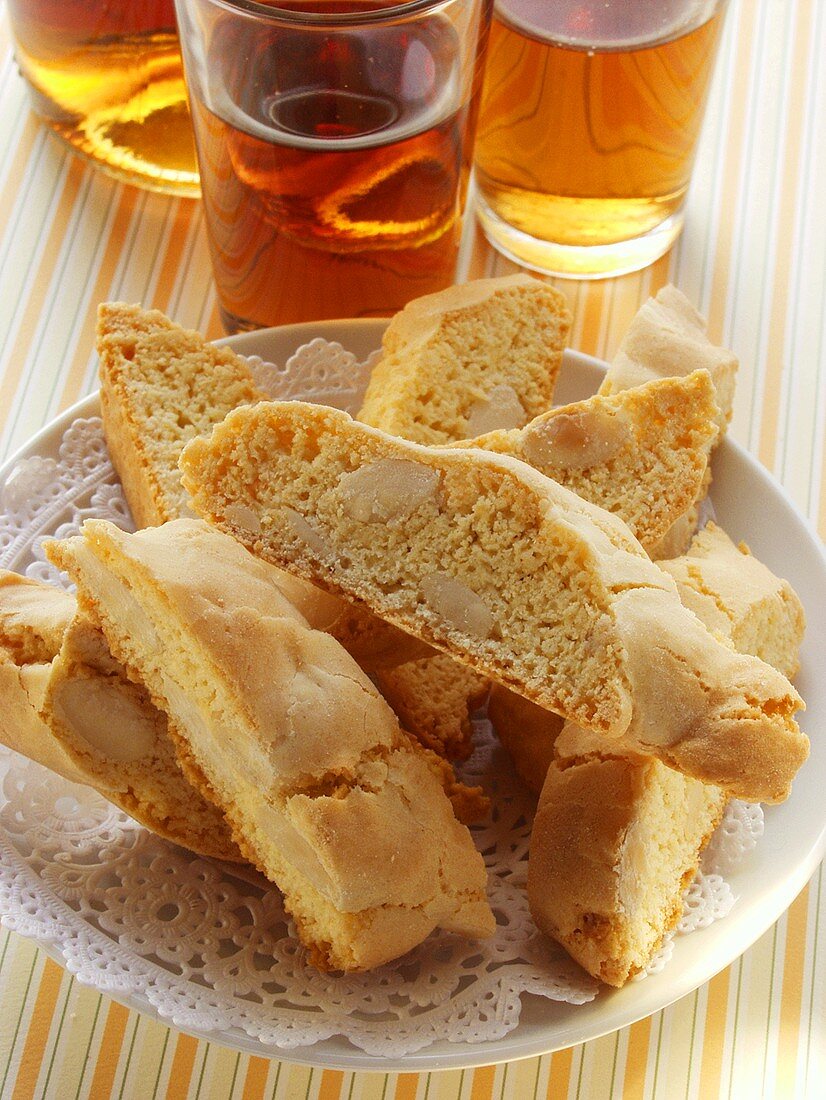 Italian almond biscuits (cantucci) on plate; Vin Santo