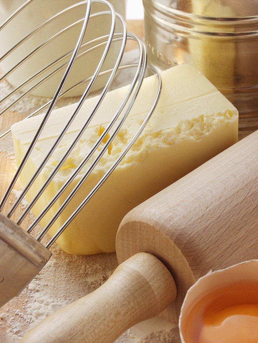 Various baking utensils, broken egg and butter