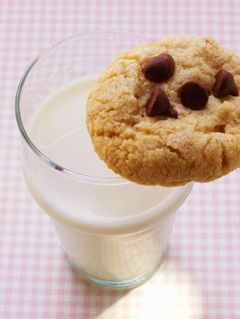 Chocolate chip cookie on a glass of milk