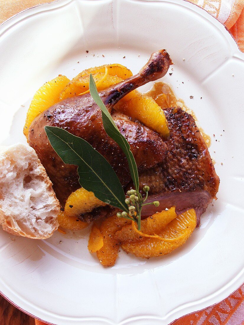 Duck with oranges, bay leaf and baguette