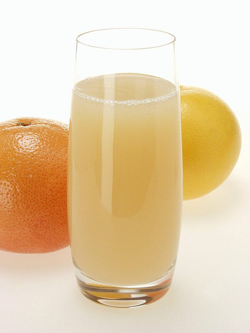 Grapefruitsaft im Glas und verschiedene Grapefruits