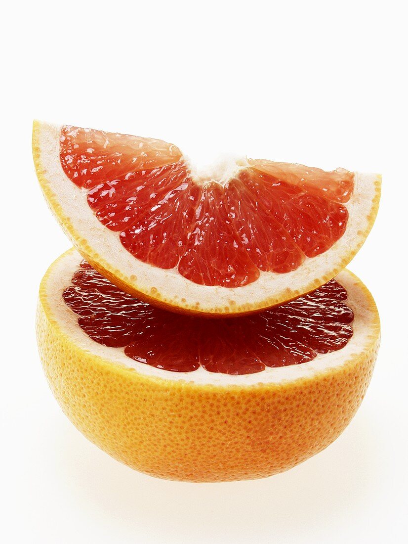 Wedge of pink grapefruit on grapefruit half