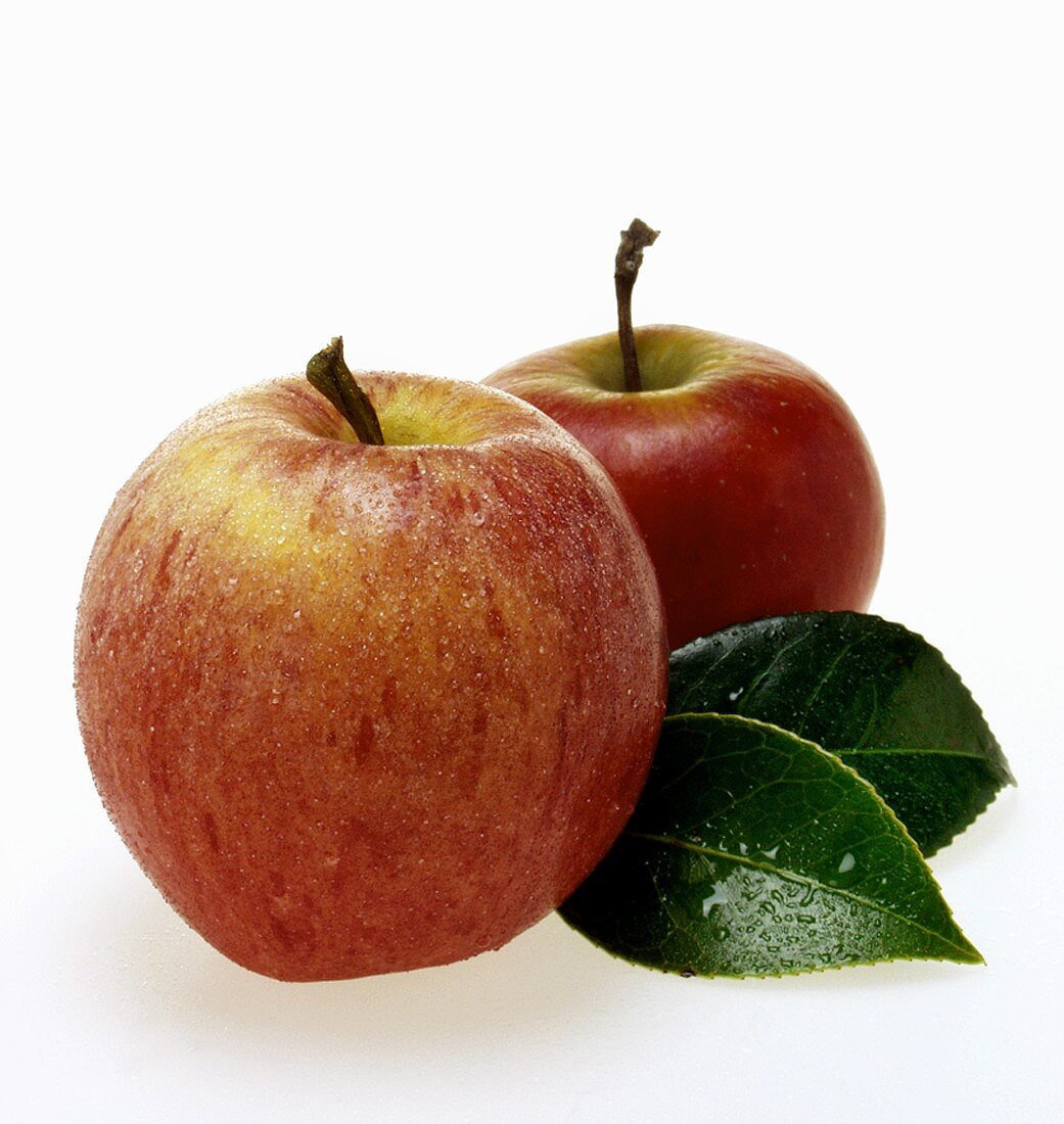 Various red apples with leaves and drops of water