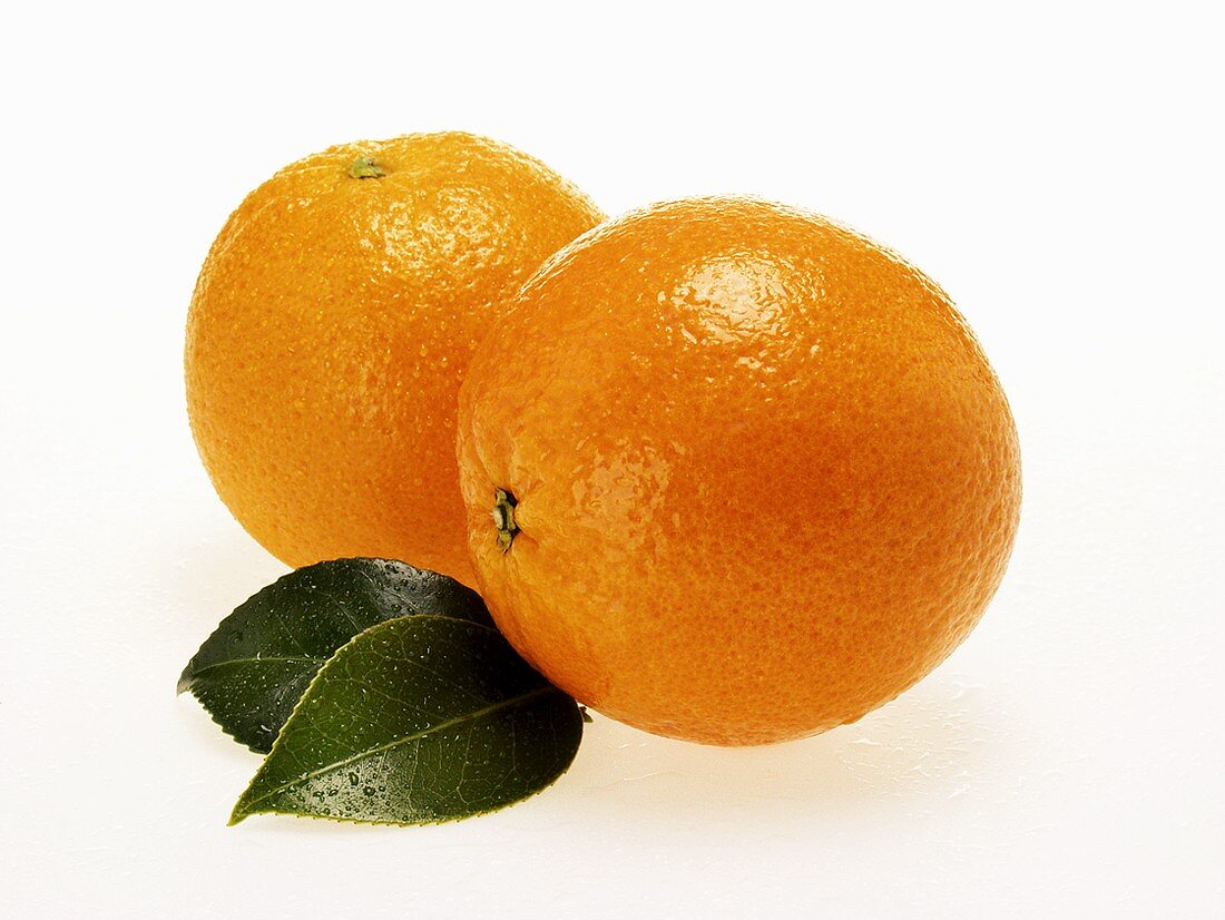 Oranges with leaves and drops of water