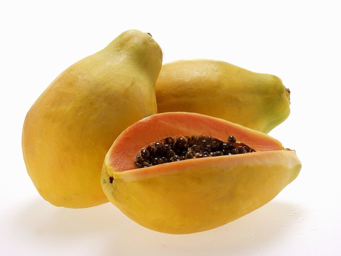 Drei Papayas, eine davon angeschnitten