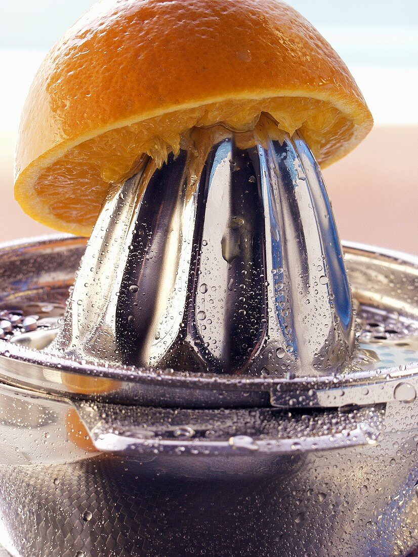 Orange on lemon squeezer with drops of water