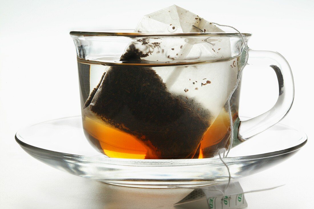 Frisch überbrühter Tee in Glastasse mit Teebeutel