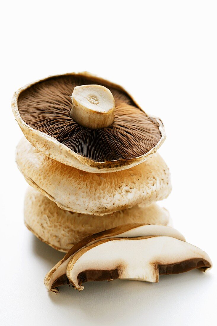 Portobello mushrooms (caps) in a pile and sliced