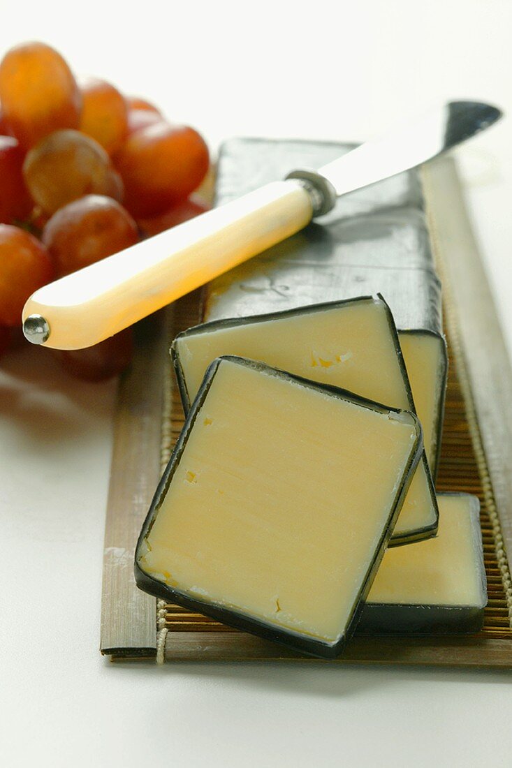 Vermont Cheddar mit Käsemesser und Trauben