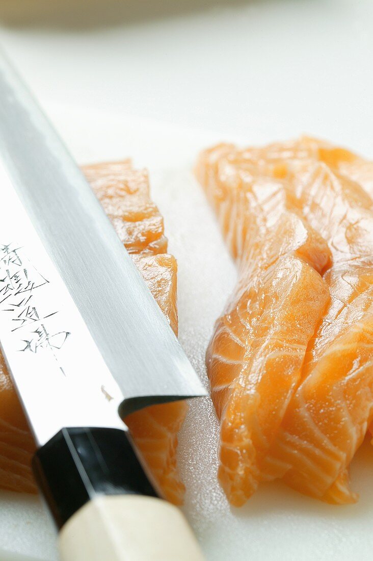 Cutting salmon for sushi