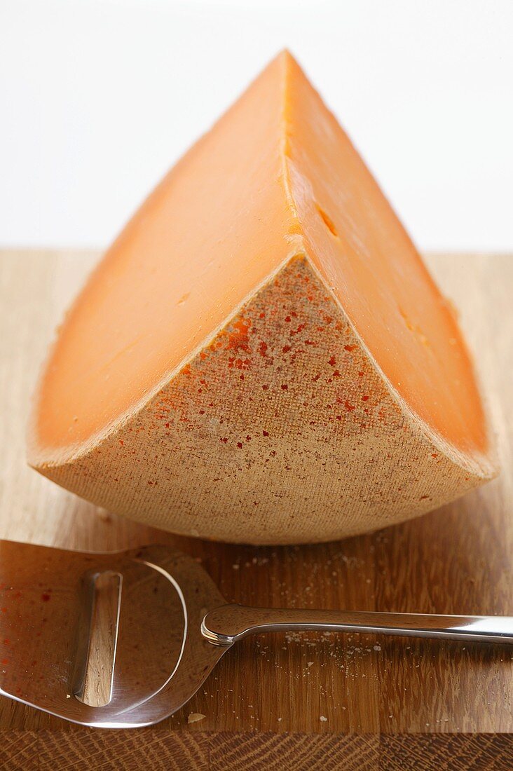 Cheddar with cheese slicer on chopping board