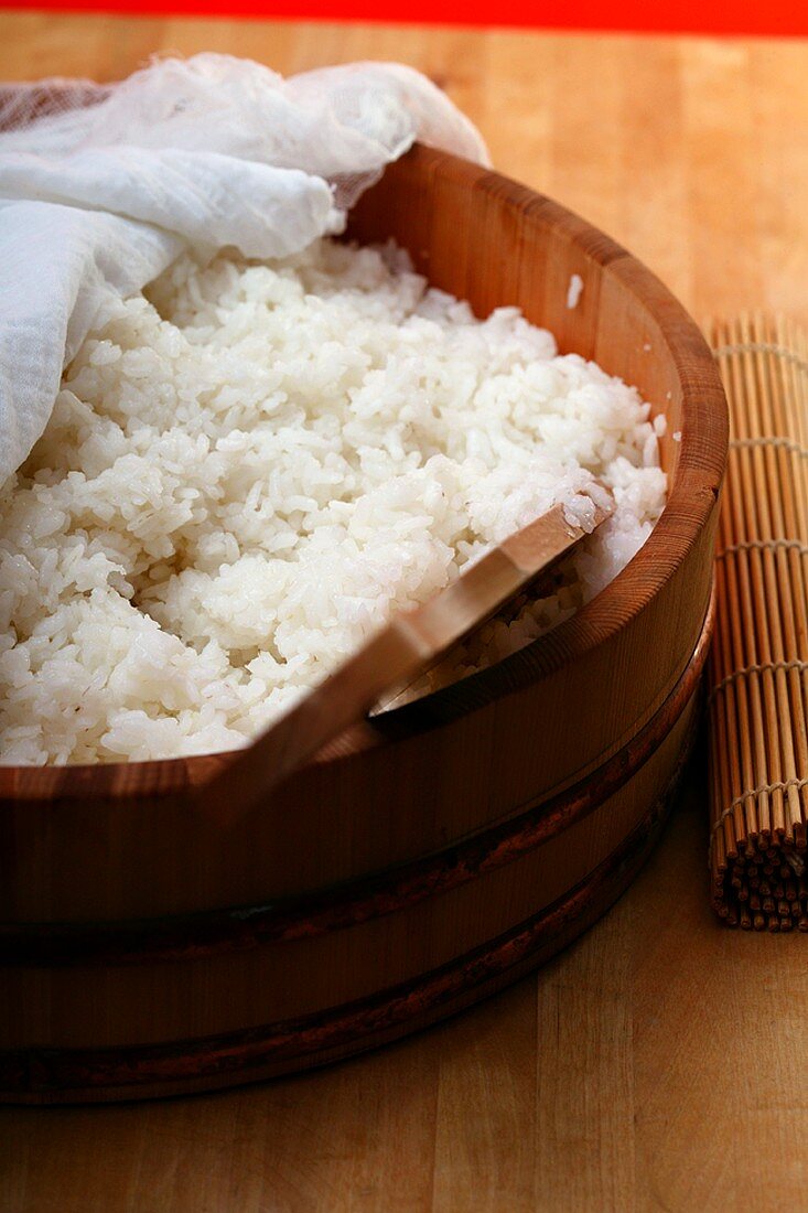 Boiled sushi rice in wooden bowl with cloth