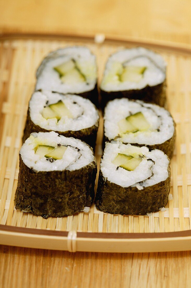 Maki-sushi with cucumber on wicker tray