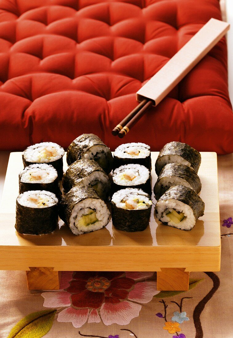 Maki-Sushi-Platte vor rotem Kissen