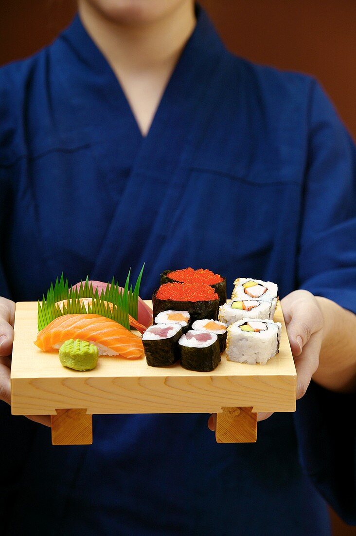 Person serving sushi platter