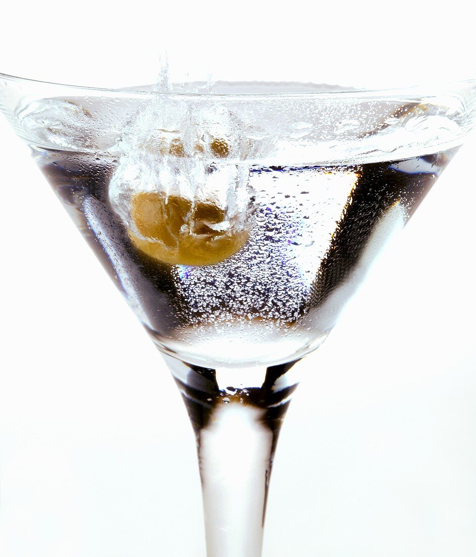 Olive falling into Martini glass