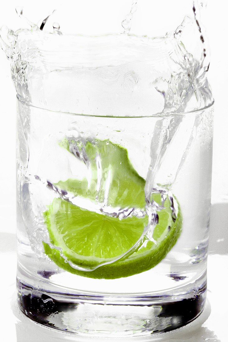 Slice of lime falling into a drink