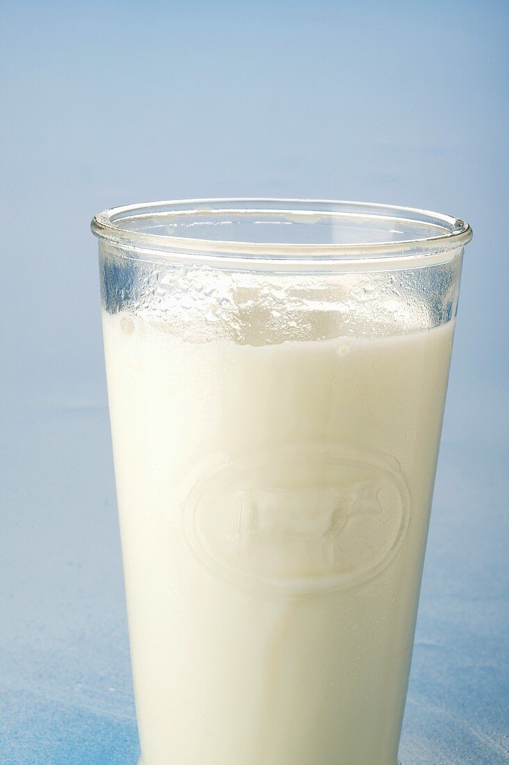 Fresh milk in glass; blue background