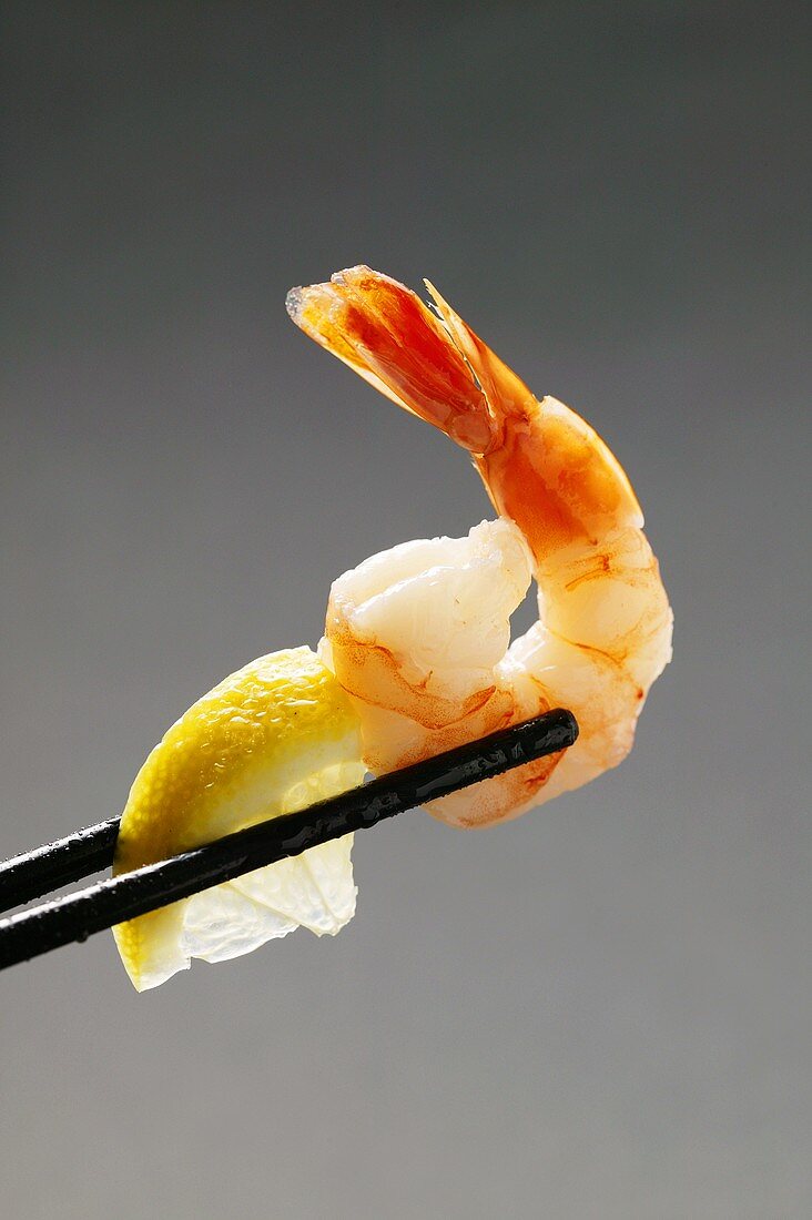 Shrimp with lemon wedge on chopsticks