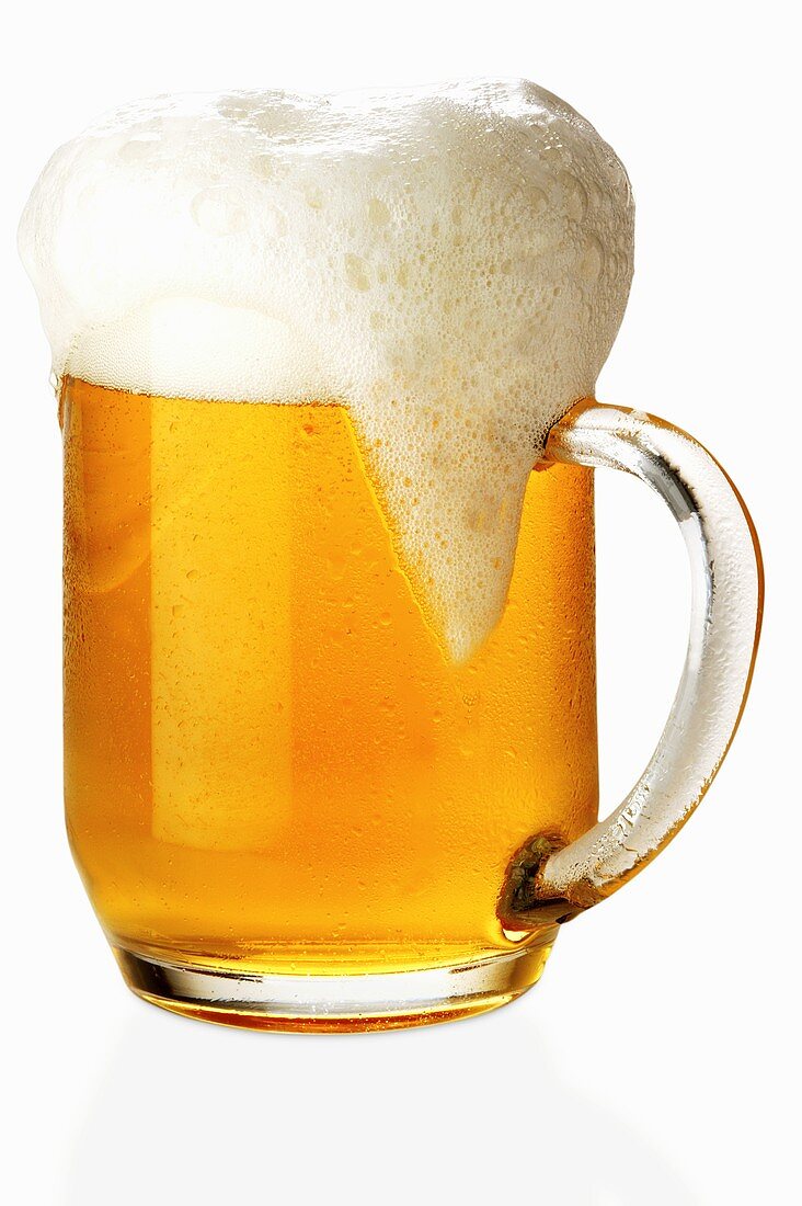 Überschäumendes helles Bier im Henkelglas