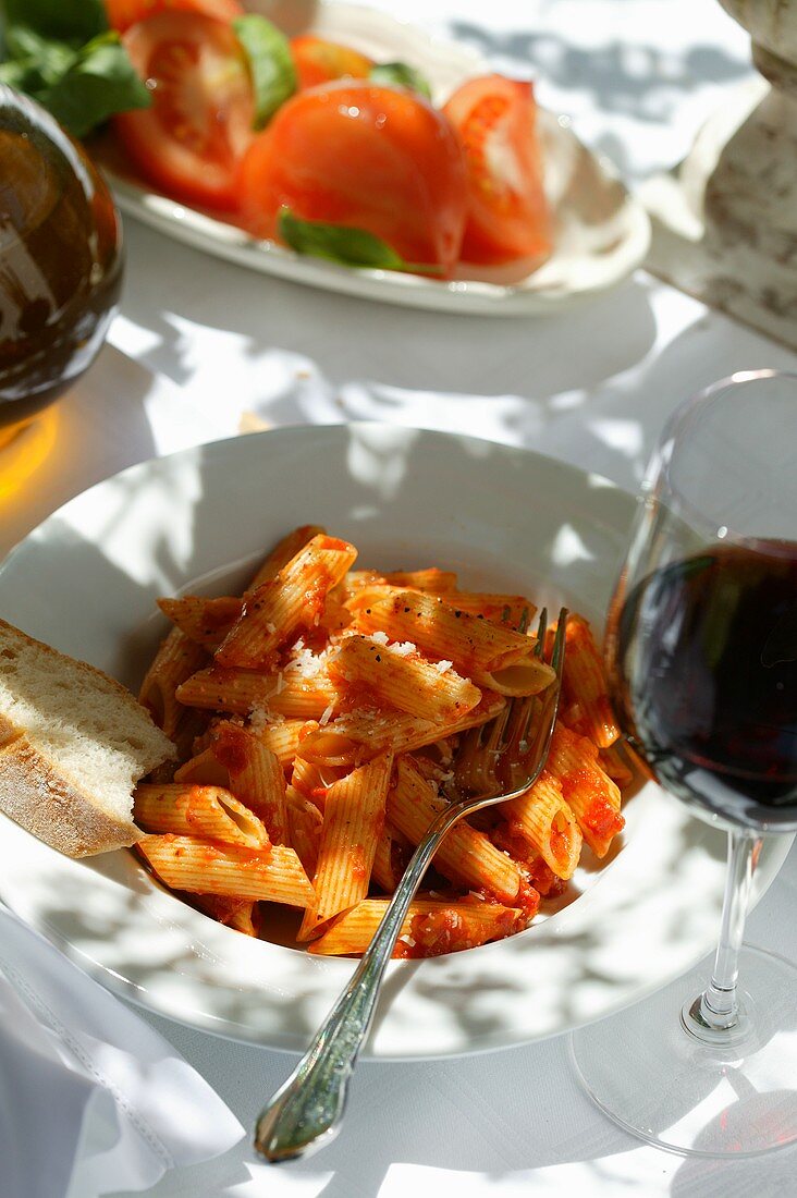 Penne rigate with tomato sauce; red wine glass