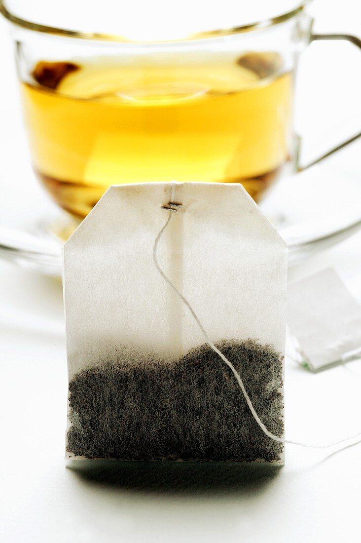 Tea bag in front of a cup of tea