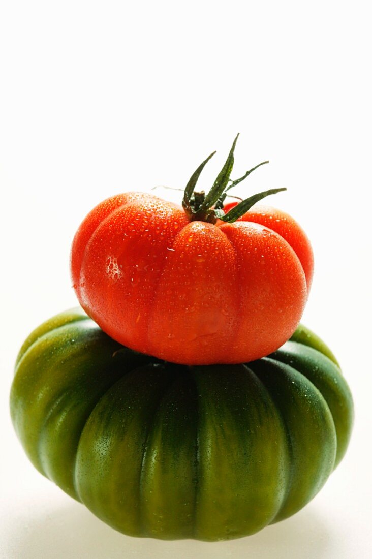 Green and red beefsteak tomato with drops of water