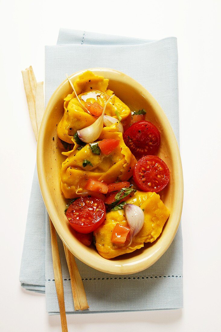 Tortellini with tomatoes and garlic; grissini