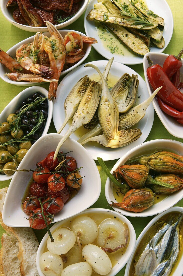 Verschiedene Antipasti: eingelegtes Gemüse, Fisch, Scampi