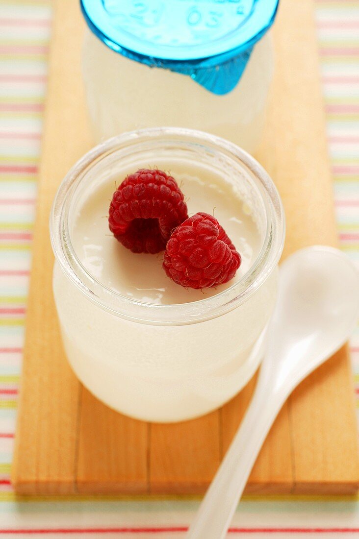 Jar of yoghurt with fresh raspberries