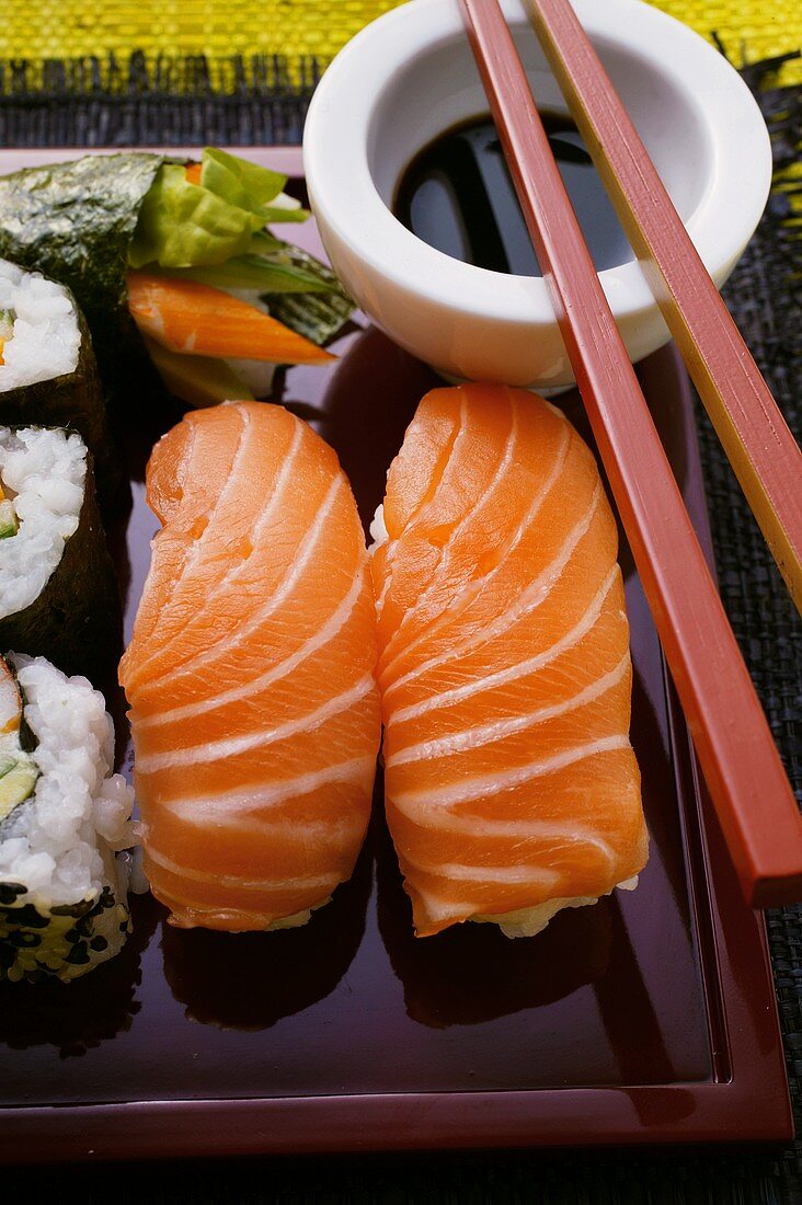 Verschiedene Sushi auf roter Platte; Sojasauce