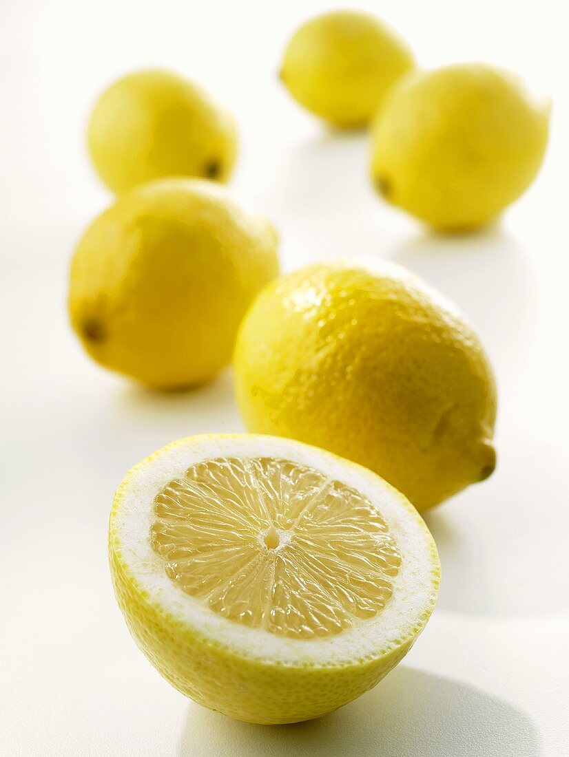Ganze Zitronen und Zitronenhälfte