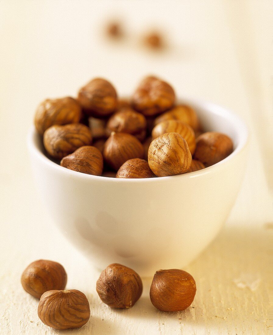 Hazelnut kernels in small white bowl