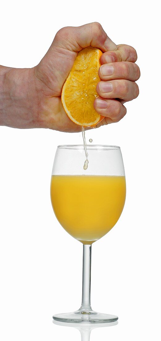 Squeezing orange into glass