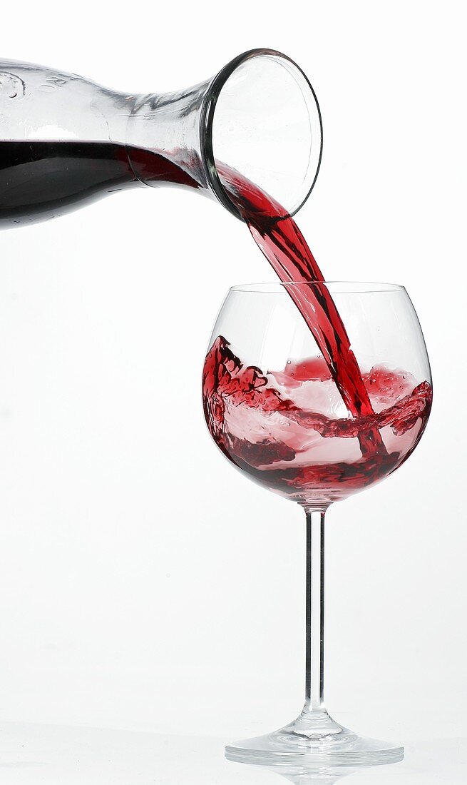 Rotwein aus Karaffe in Glas gießen