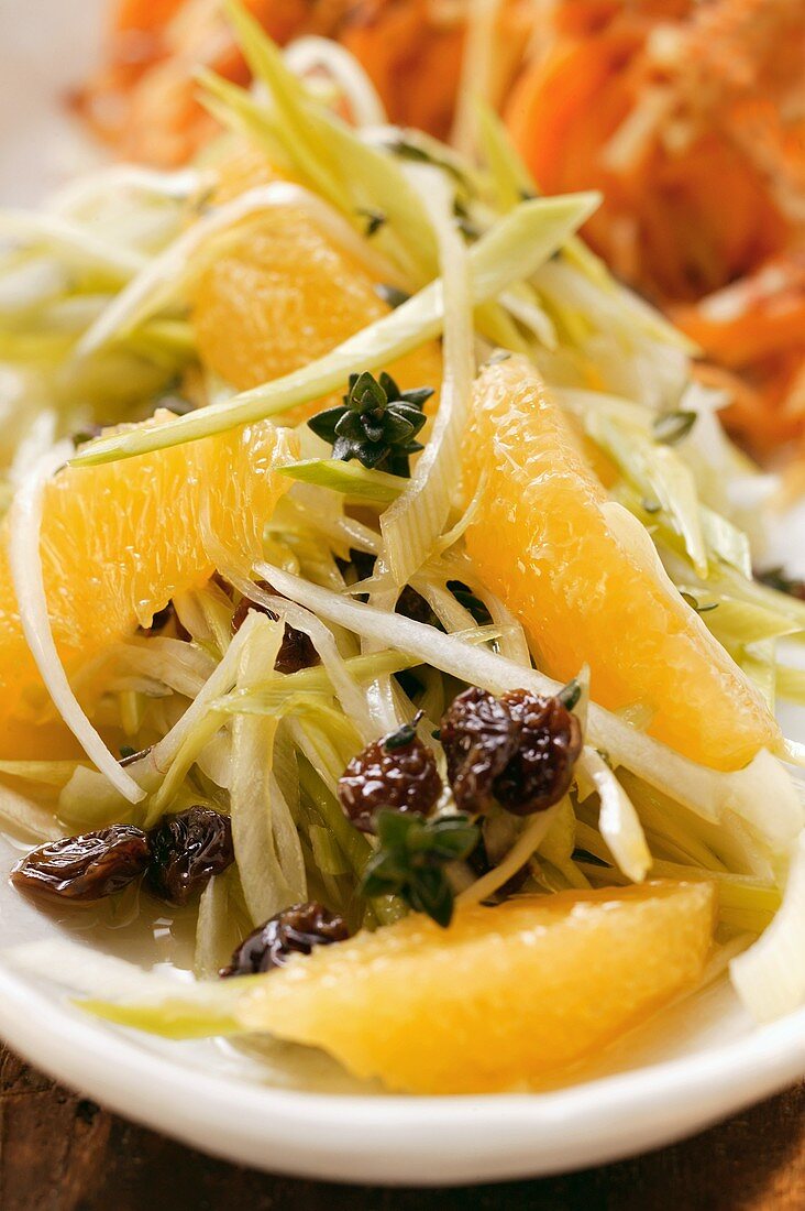 Raw vegetable salad with leeks, raisins and oranges