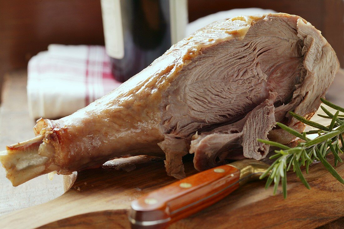 Roast turkey leg with knife on chopping board