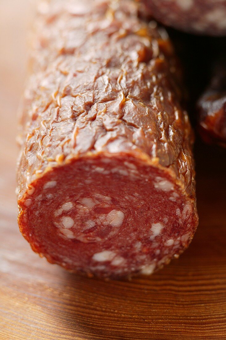 Eine Stange Wildwurst (Salami), angeschnitten