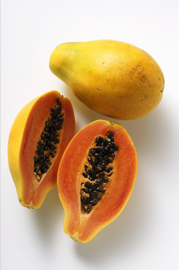 Ganze und halbe Papayas