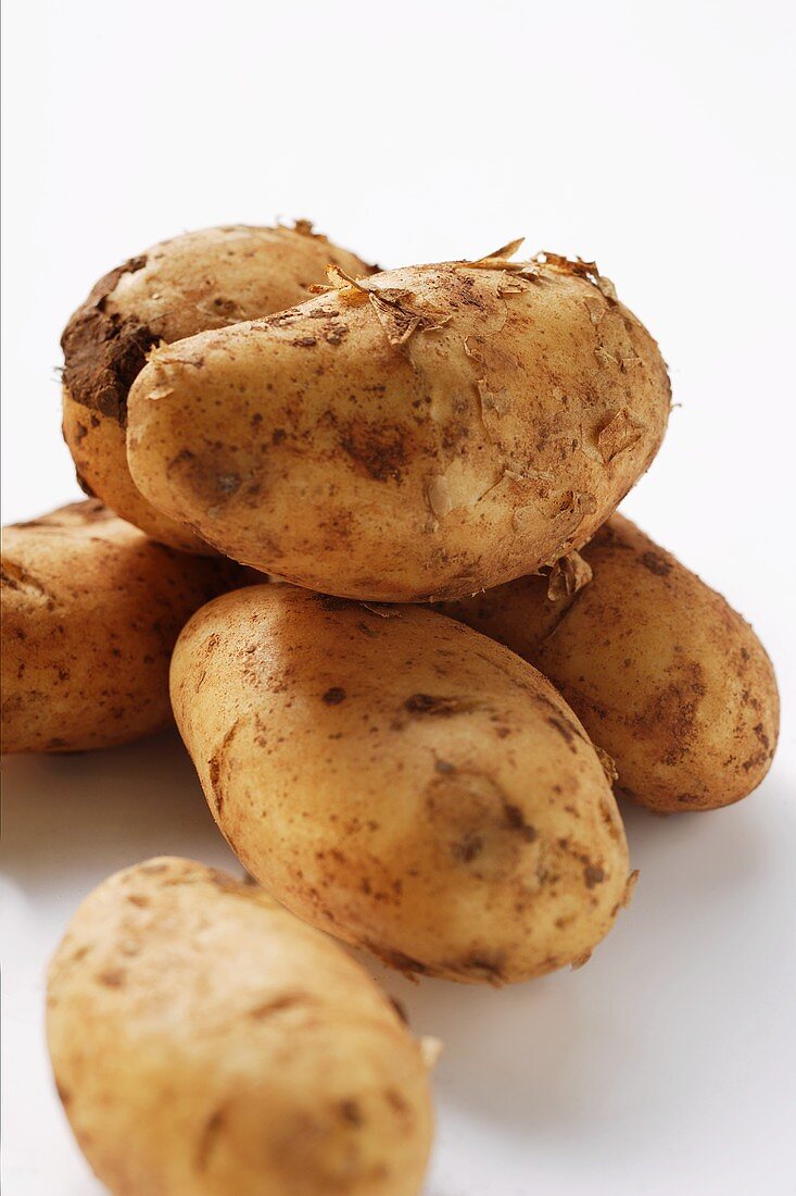 Several potatoes with soil