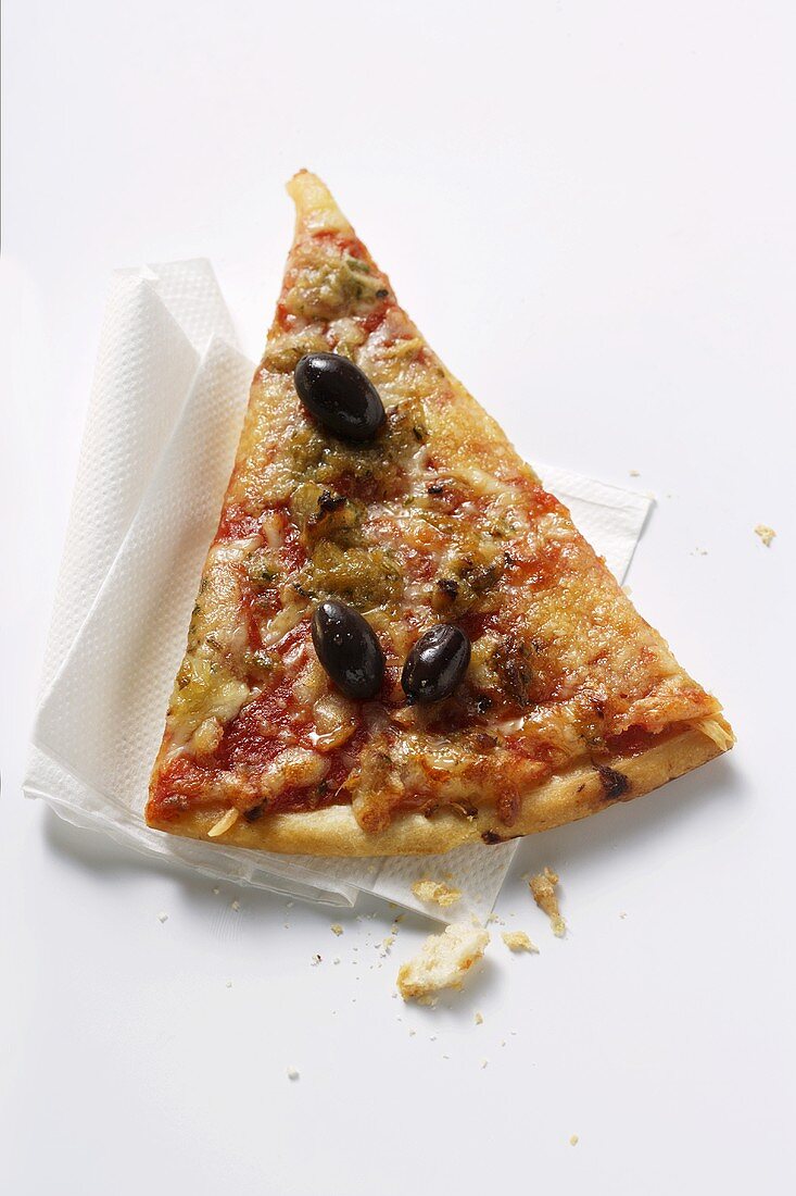 A piece of pizza with tuna and olives on napkin