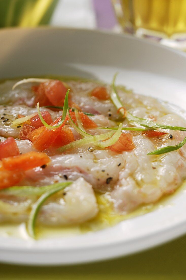 Carpaccio aus rohen Garnelen, Tomaten und Frühlingszwiebeln