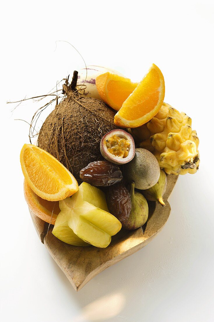 Exotic fruit still life with coconut in wooden bowl